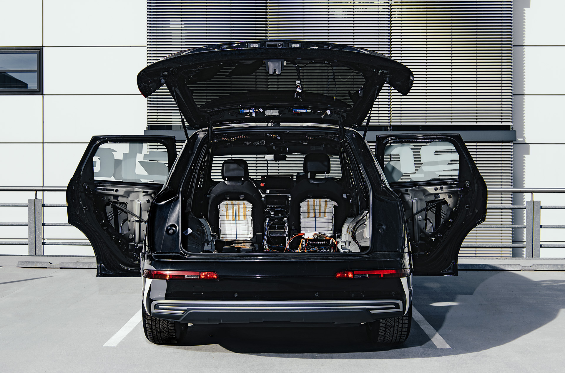 A view from the rear of the Brutus concept car with its tailgate and side doors open to reveal the electronics in the trunk and removed interior panels.