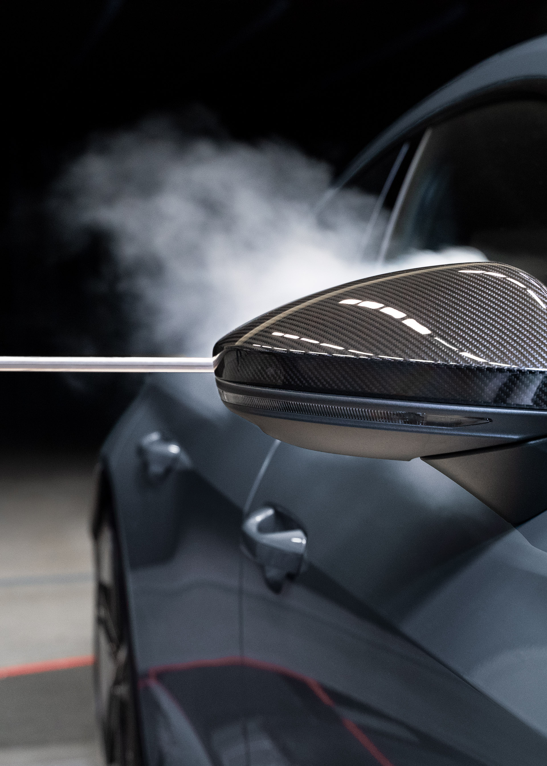 Smoke flows along the body of the Audi RS e-tron GT{ft_rs-e-tron-gt} after passing the exterior mirror.