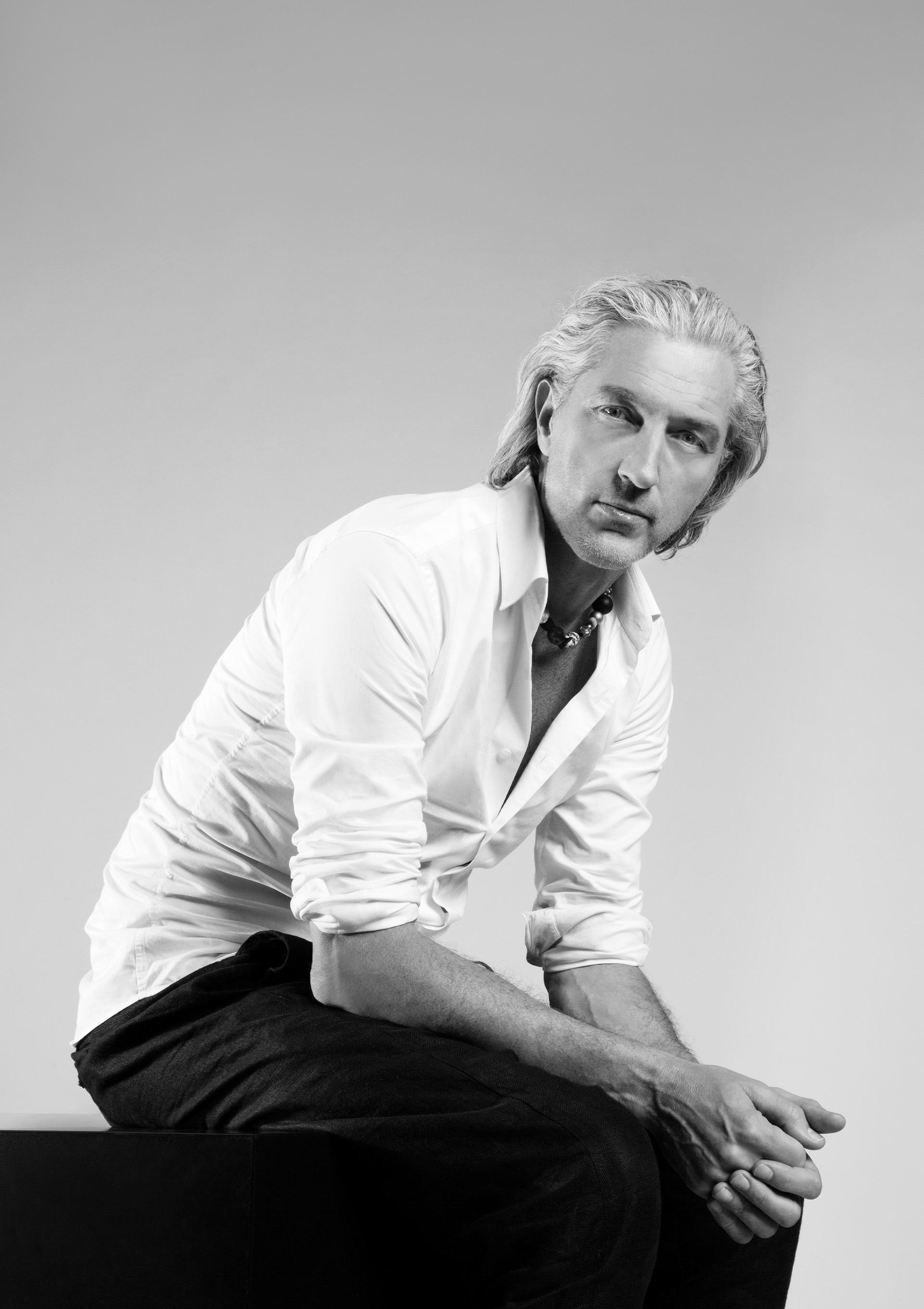 Marcel Wanders sits and looks directly into the camera with his hands clasped.