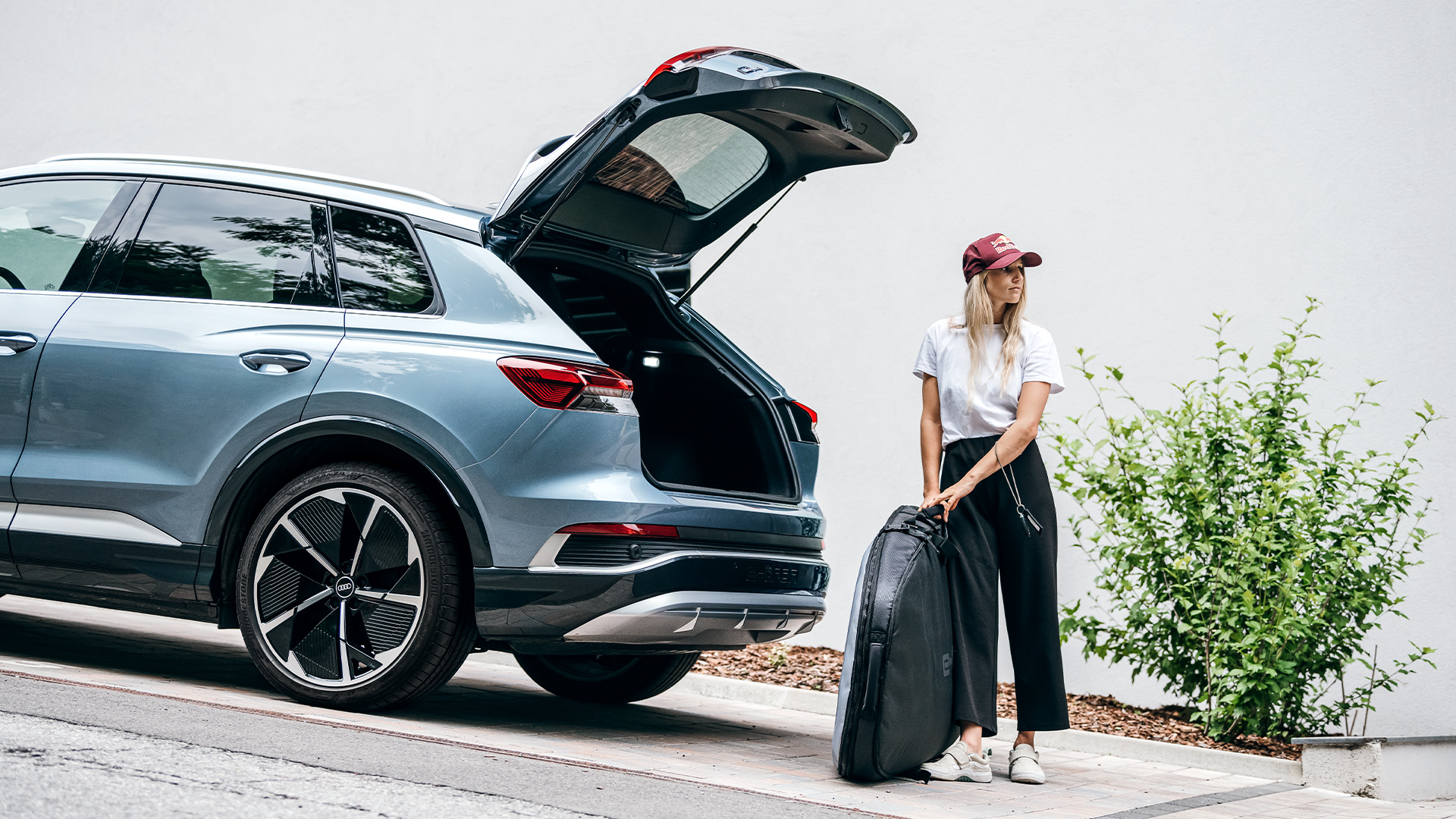 Anna Gasser stands by the open trunk of her Audi Q4 e-tron.