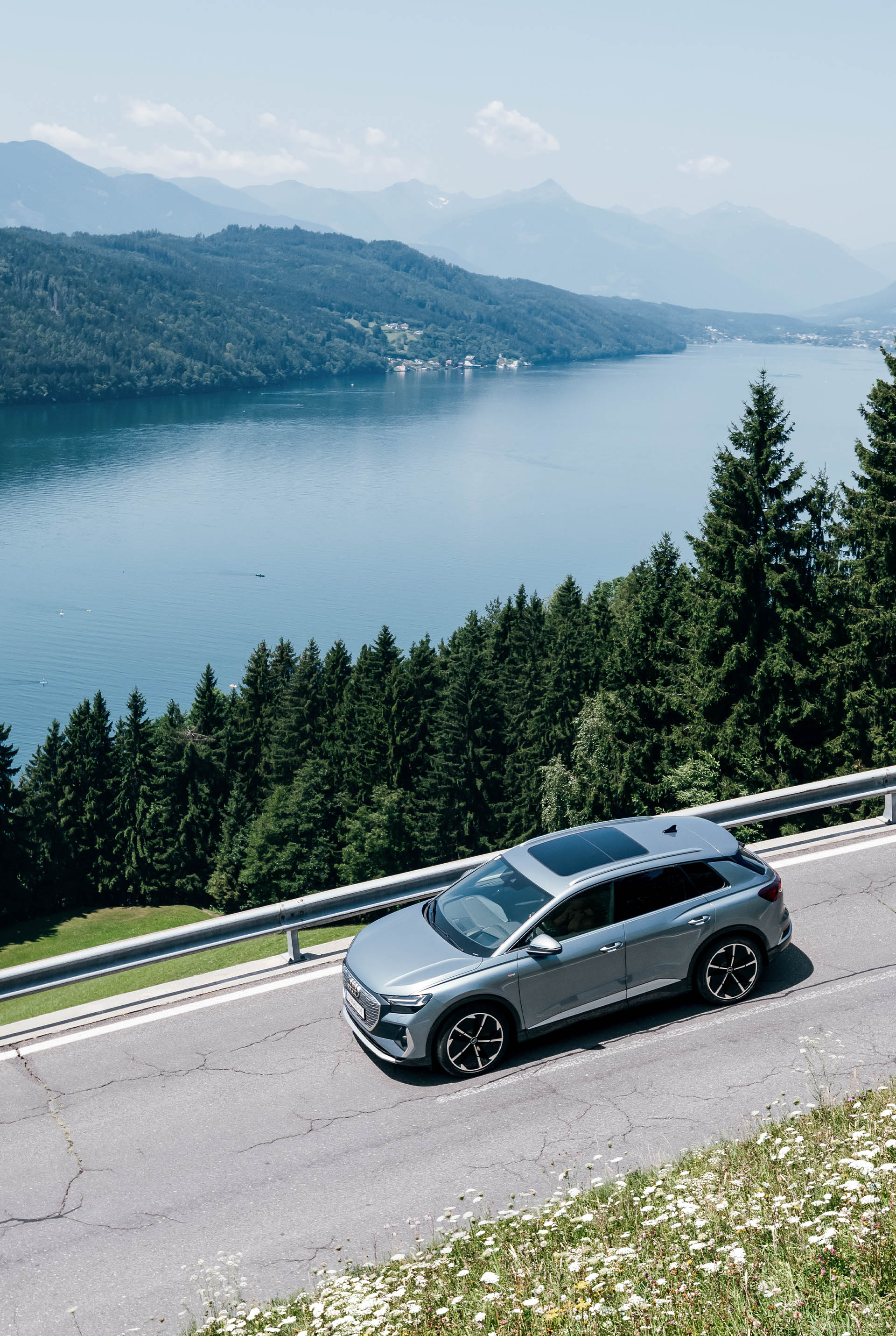 A view of a moving Audi Q4 e-tron by a lake.