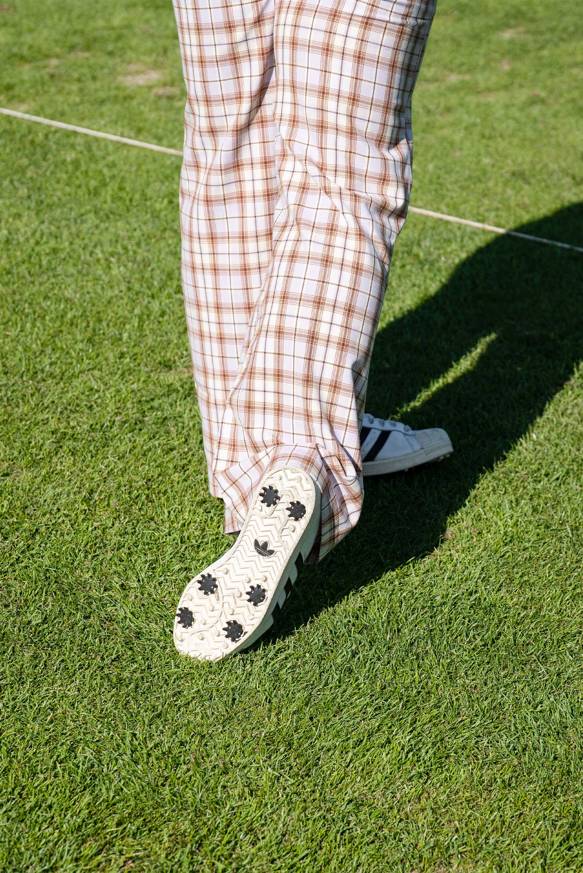 A detail shot of the check golf pants and sneakers that Mullins wears on the course.