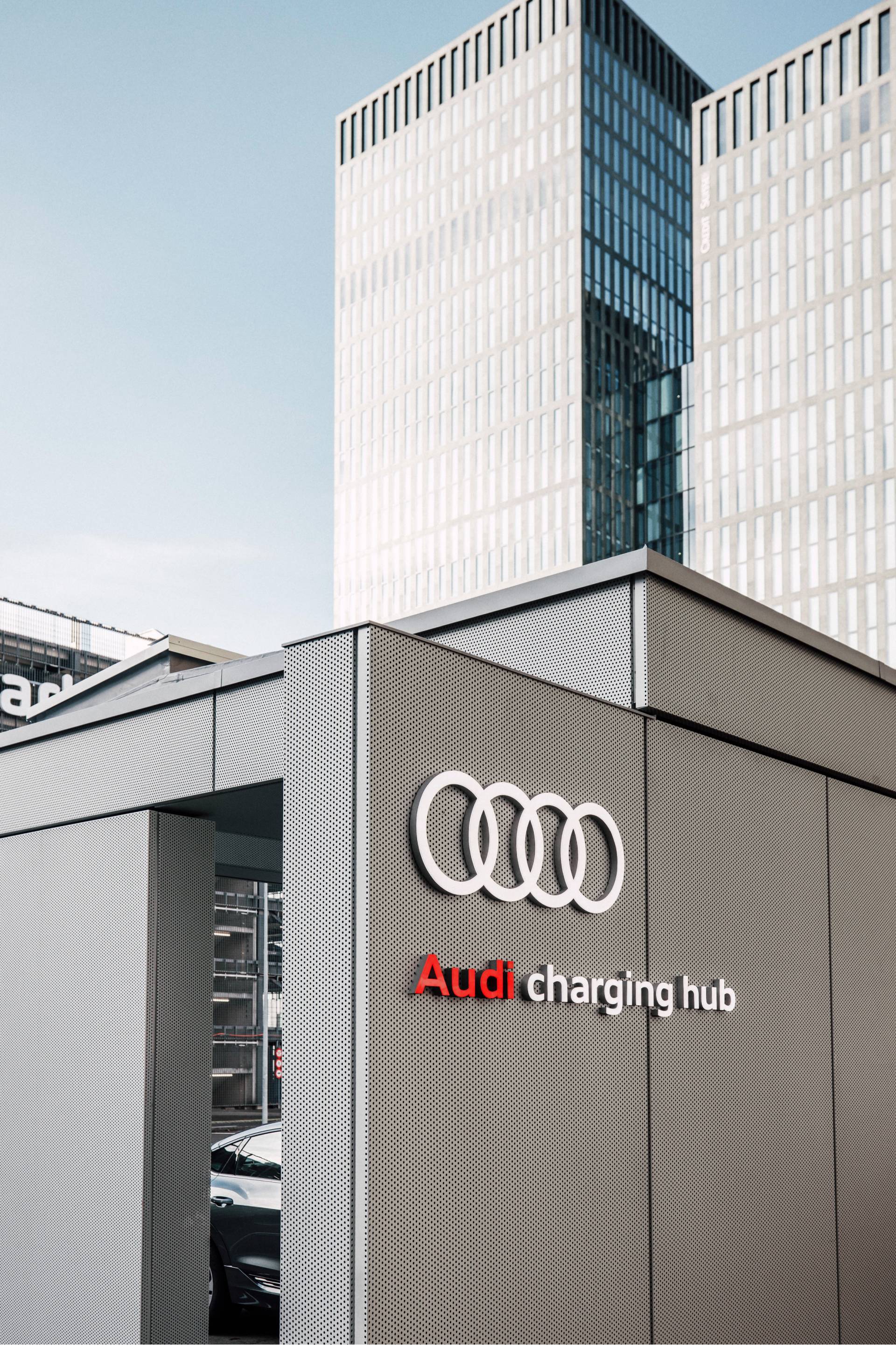 Audi charging hub, high-rise buildings in the background.