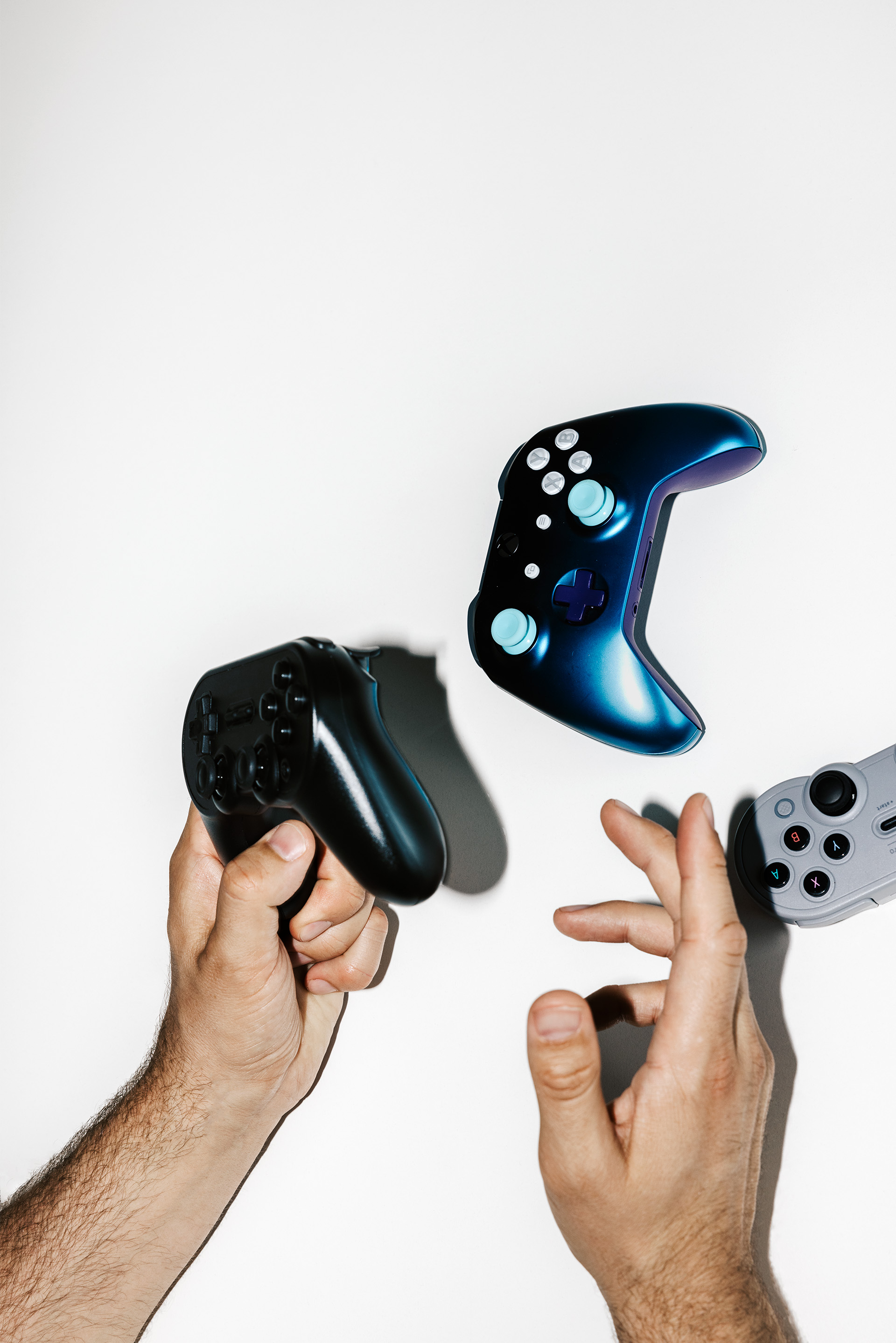 A hand and several controllers can be seen.