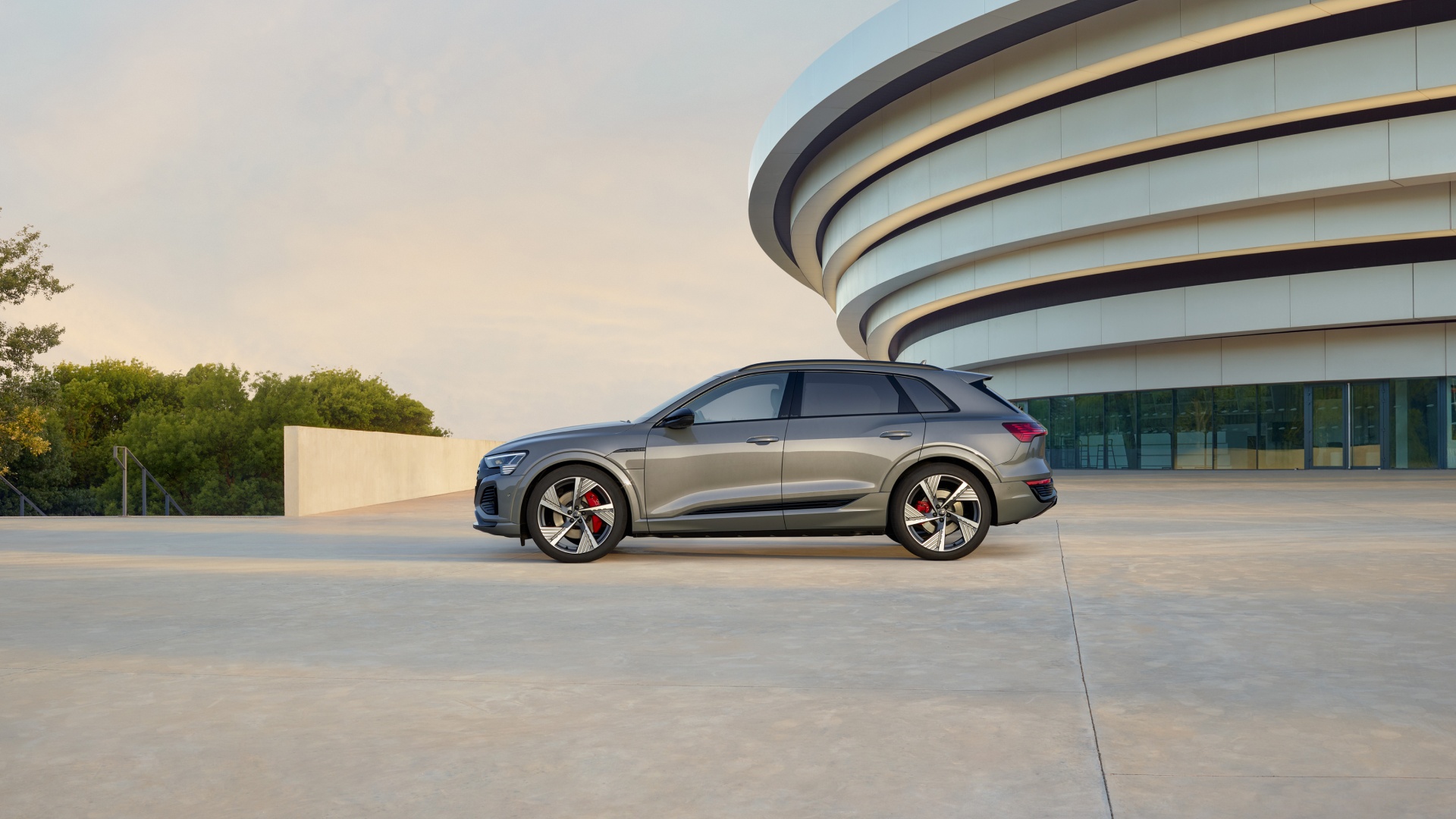 An Audi Q8 e-tron SUV stands in front of a building.