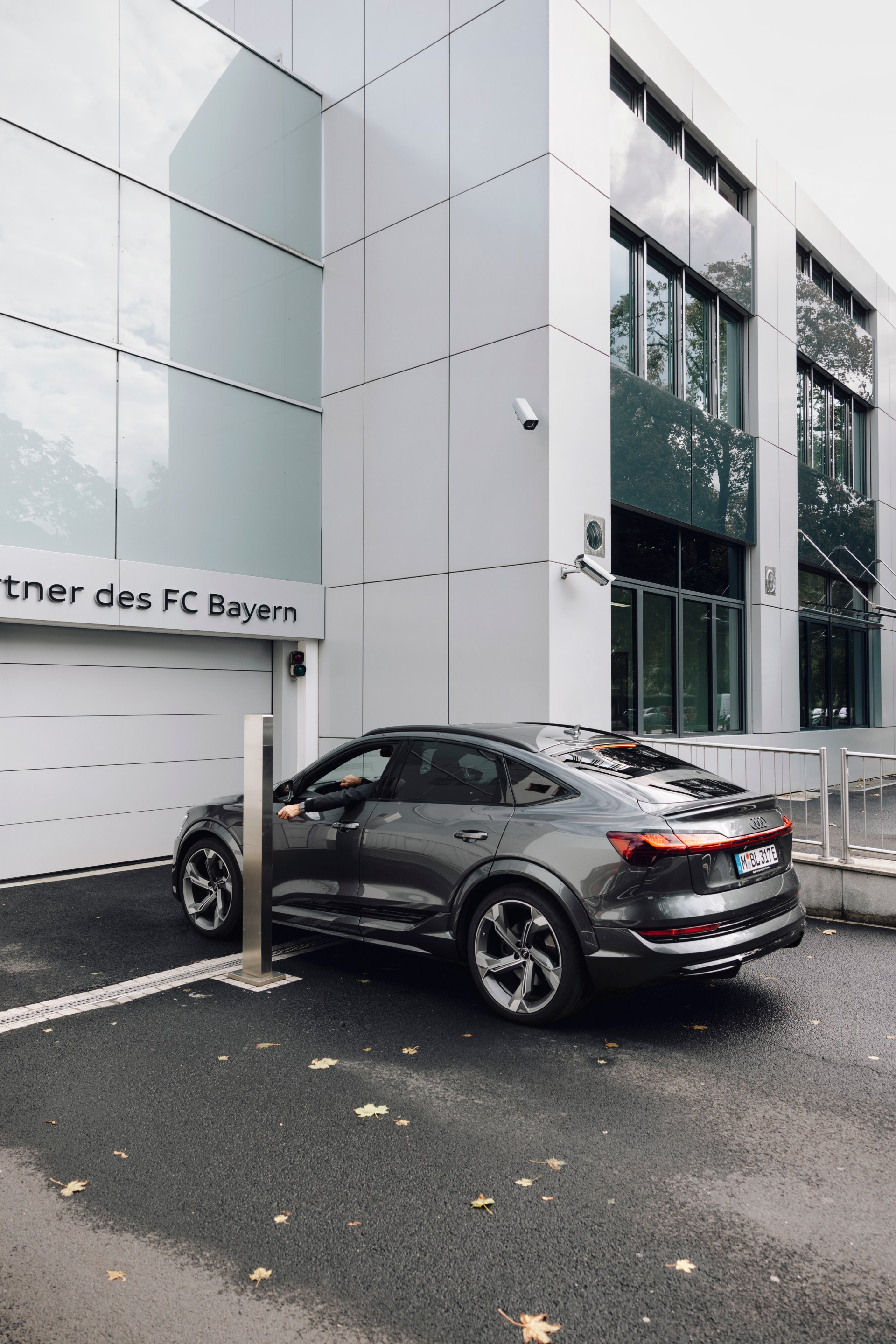 The Audi e-tron S Sportback is parked in front of the gate to the underground car park.